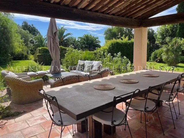 Terrasse spacieuse avec mobilier confortable et vue sur le jardin luxuriant.