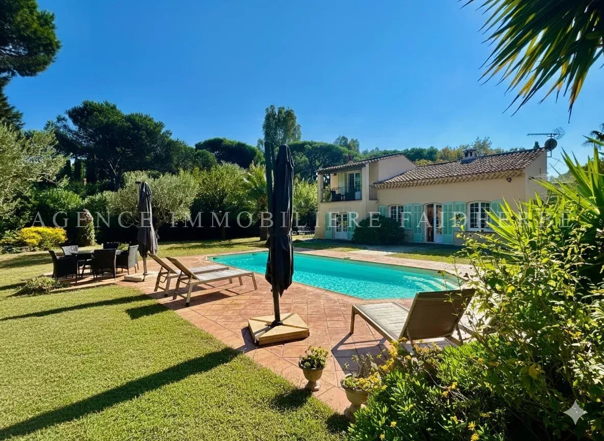 Belle maison avec piscine et grand jardin fleuri.