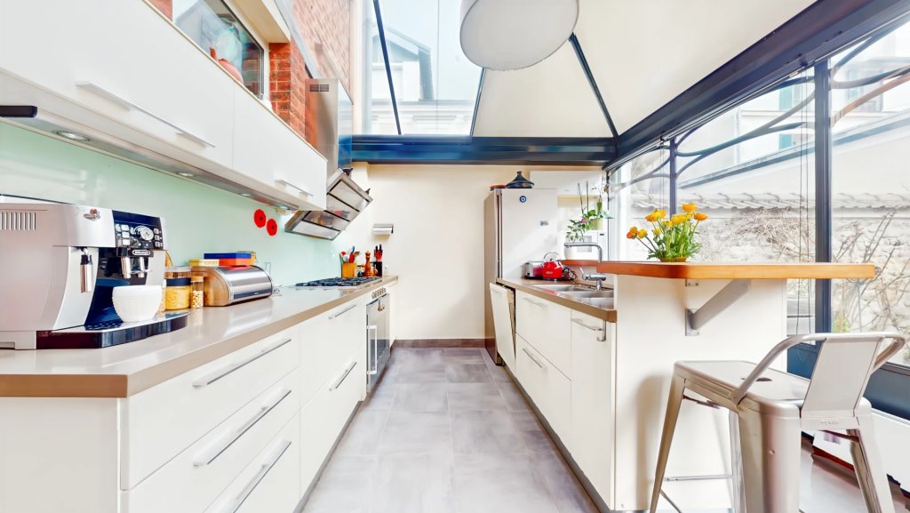 Cuisine installée sous véranda, ouverte sur le jardin