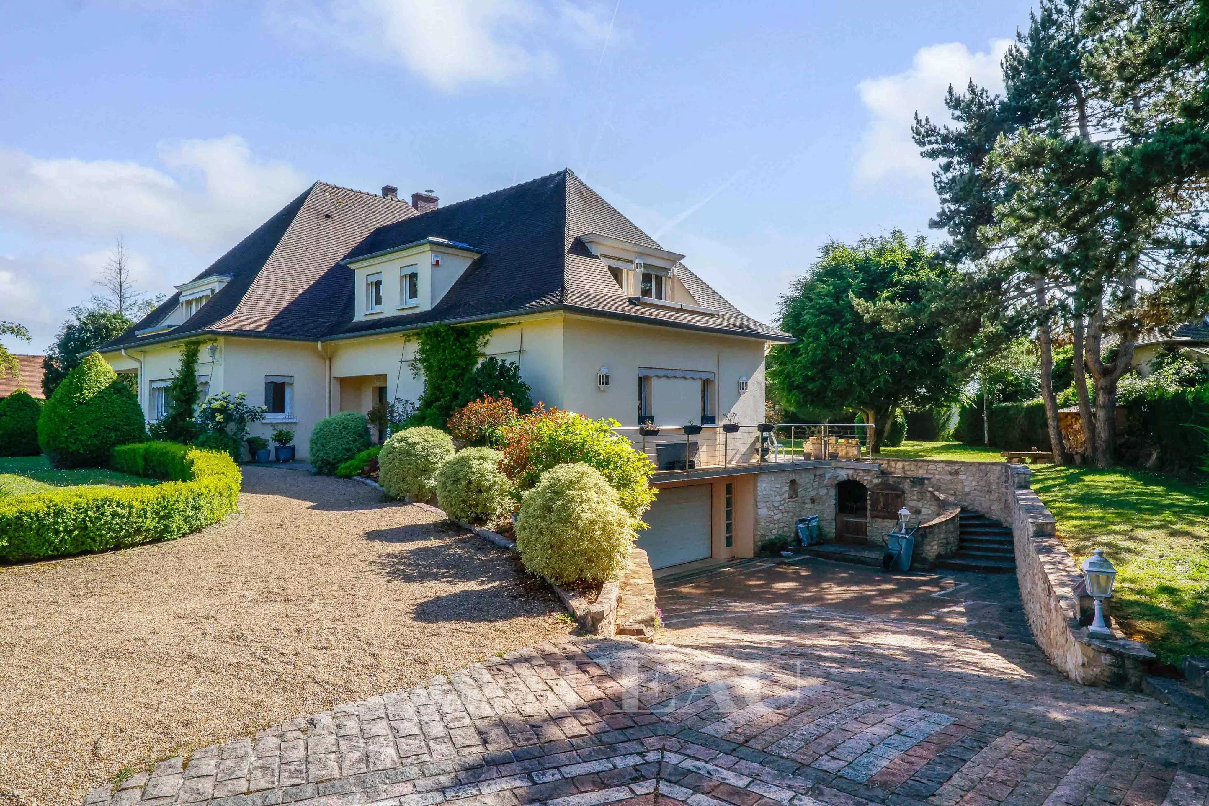 Vue sur la façade Est de la maison et l'entrée du garage