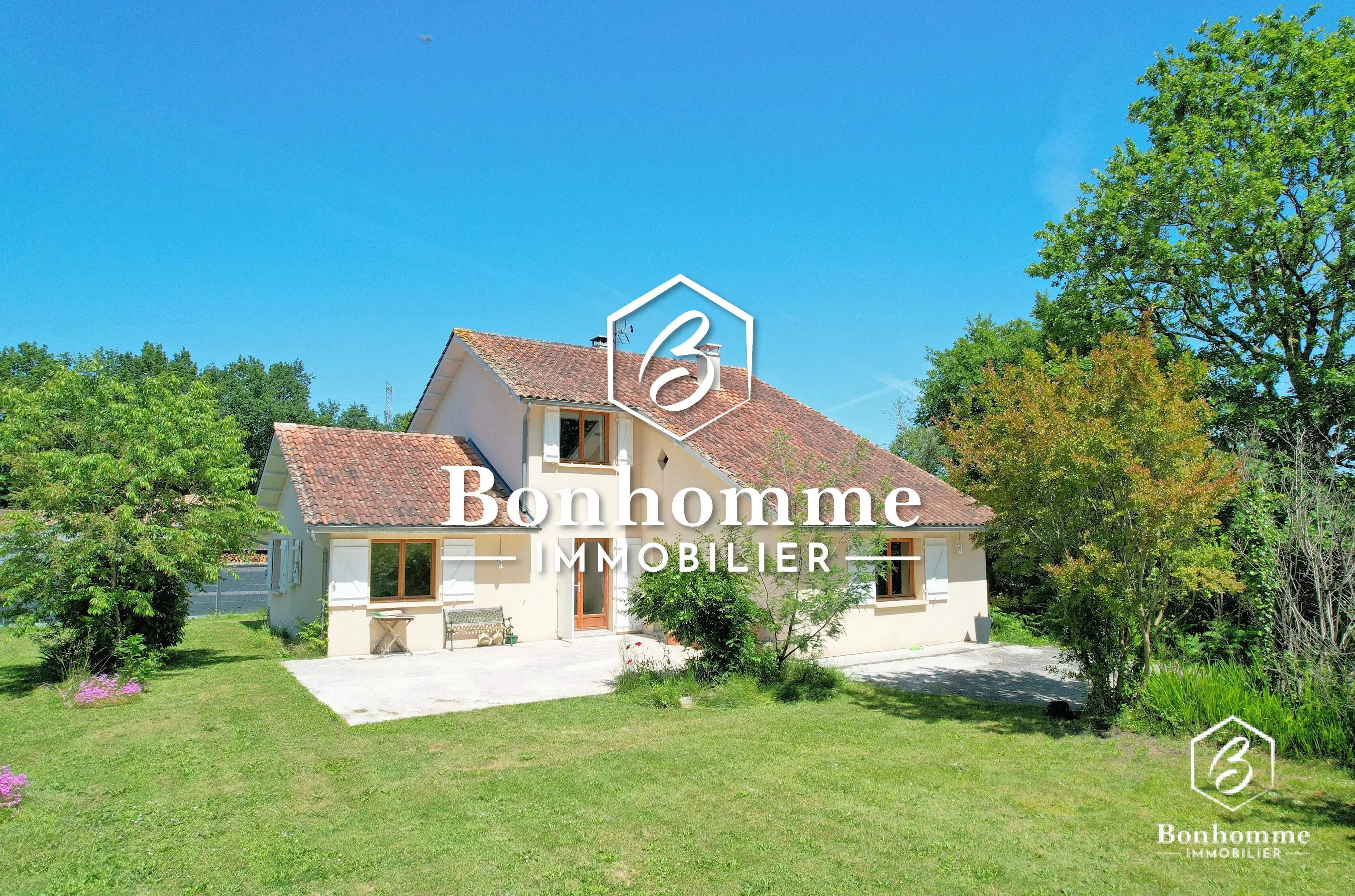 Belle maison spacieuse entourée d'un grand jardin verdoyant.