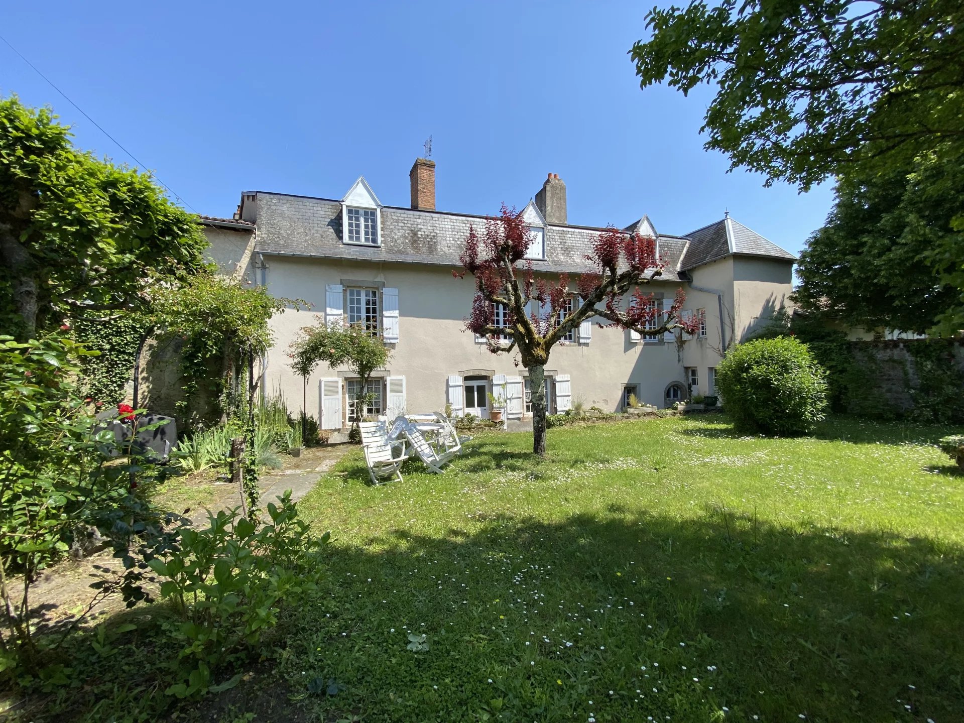 Demeure de caractère au Dorat – Une maison avec un joli jardin et un garage