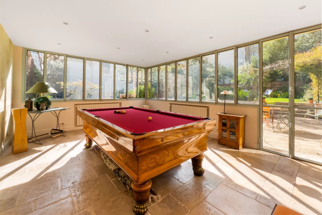 Salle de billard ouverte sur le jardin par une verrière