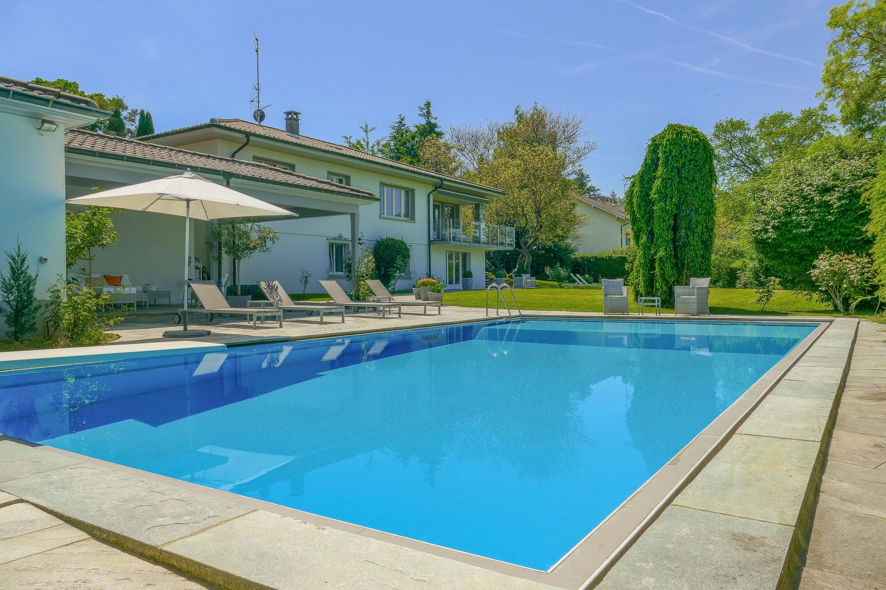 Magnificent villa with a swimming pool, set in a lush green environment and offering breathtaking lake views.