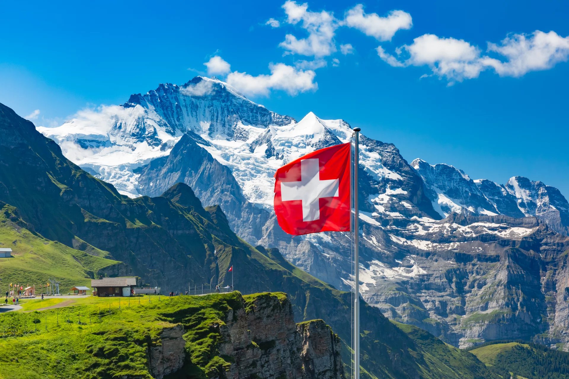 jungfrau,swiss flag,alps,flag,cliff,monch,destination,tourism,ice,swiss alps,skyline,aerial,scenic,summit,house,summer,rock,mountain,view,top,grass,jungfrauregion,bernese oberland,landmark,europe,pict